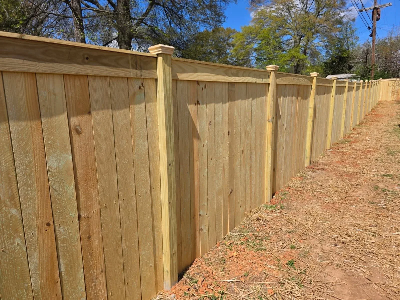 Long wooden privacy fence with finished posts